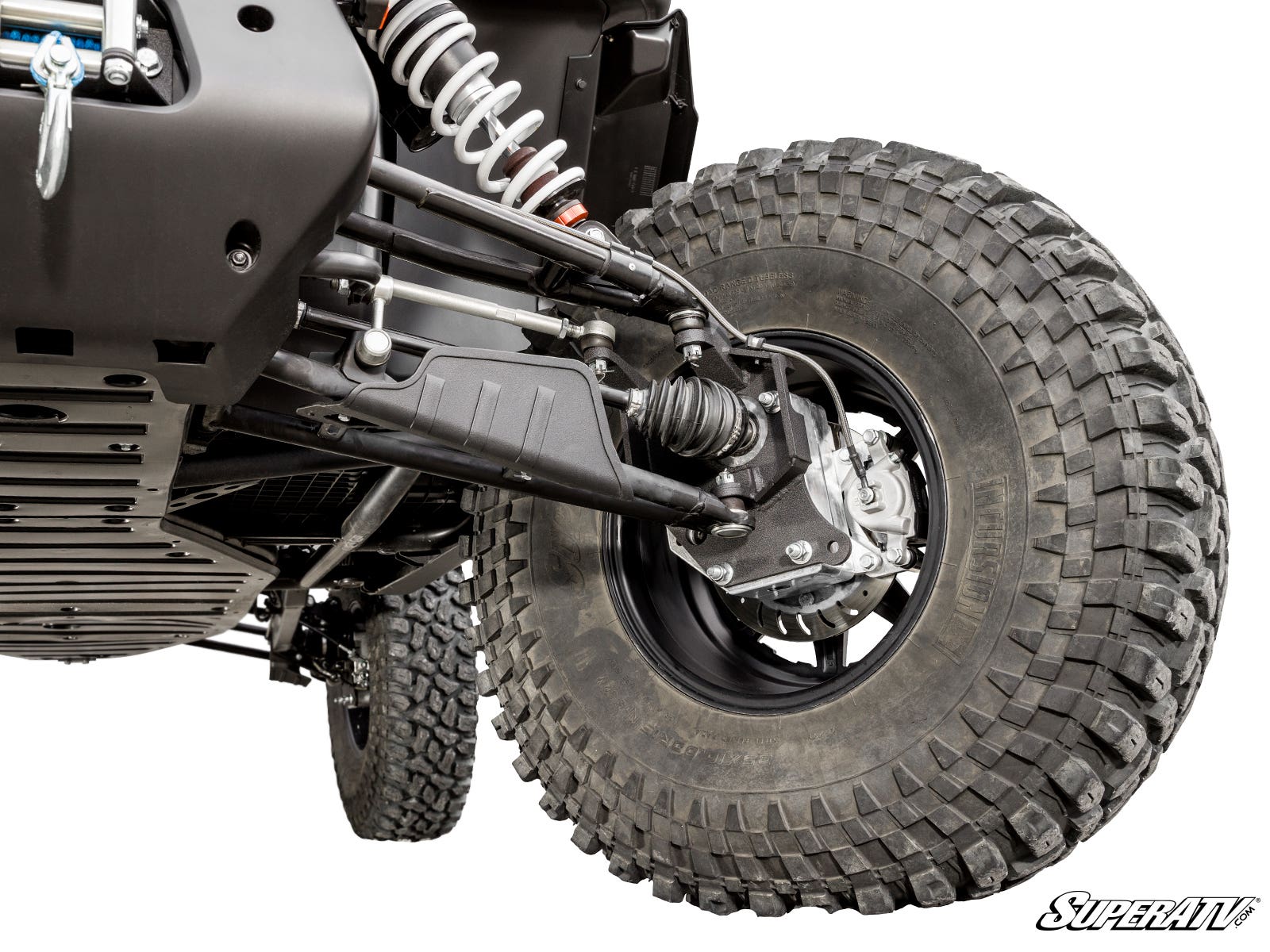 Close-up of a CFMOTO ZForce 950 HO with the 4 Portal Gear Lift shows rugged, deep-tread tire, exposed shocks, control arms, CV axle, brake disc, and a black metal skid plate. SuperATV logo appears bottom right.