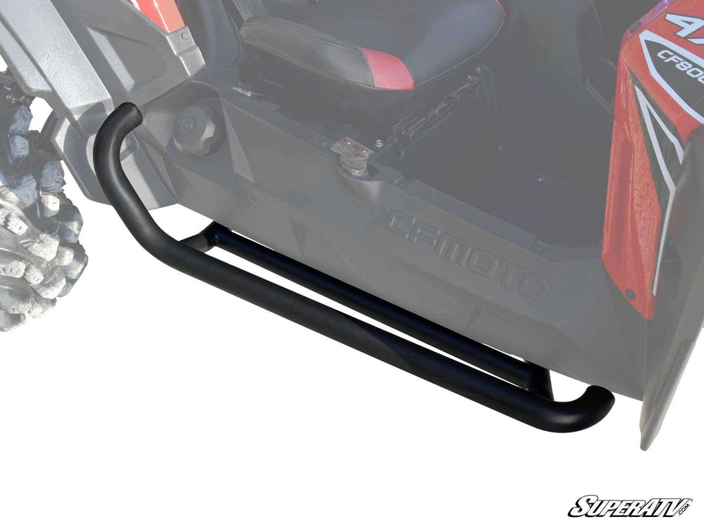 A CFMOTO ZForce Heavy-Duty Nerf Bar is mounted below the door of this off-road vehicle, running parallel to the side for step access and protection. Part of the front wheel and a red seat are also visible.