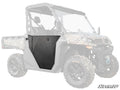 A black metal CFMOTO UForce 1000 Aluminum Door is installed on the drivers side of a camouflage-patterned off-road utility vehicle, with the rest of the vehicle faded out to highlight the door. The SuperATV logo appears in the bottom right corner.