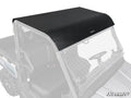 The CFMOTO UForce 1000 Aluminum Roof, finished in matte black, is mounted on the vehicle with visible bolts. Its flat design features a slightly curved front edge, and the cab, windshield, and steering wheel are seen from an angled side view.