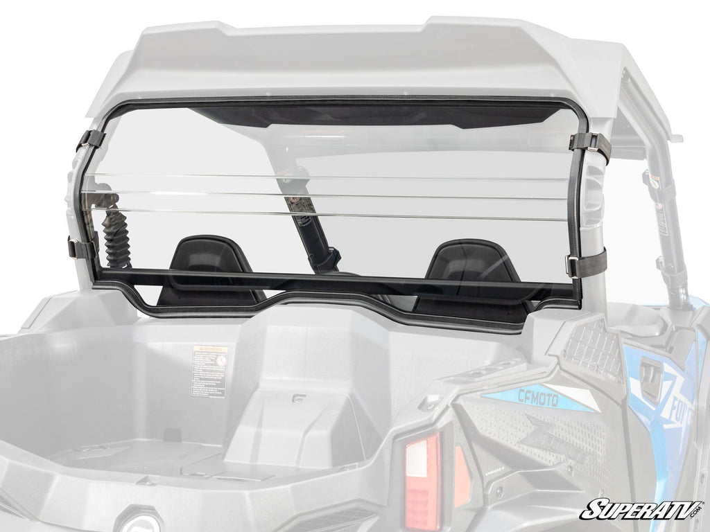 A clear CFMOTO ZForce 800 Trail Rear Windshield with a sliding vent is mounted on a gray UTV, secured by black brackets. The fit shows the cargo bed, roll cage, and rear suspension. The “SuperATV” logo appears in the bottom right corner.