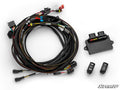 A CFMOTO ZForce 950 Deluxe Self-Canceling Turn Signal Kit is shown on a white surface, featuring a coiled cable bundle with connectors, a black SuperATV control unit, and two black electronic rocker switches with white icons and text.