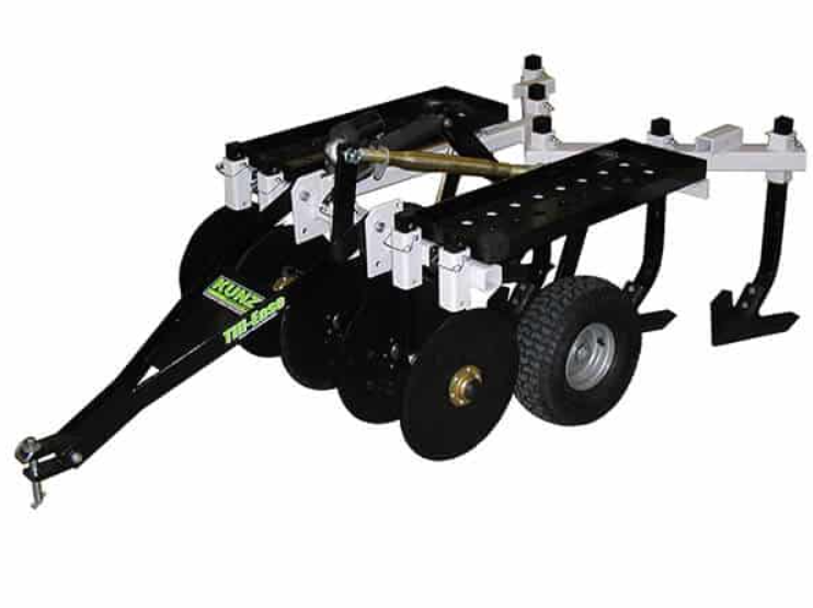 The Chisel Plow Till-Ease Model 543 is a black and white metal farm implement with two wheels, sharp disc blades, and pronged tines, designed for soil tilling and attaches to a tractor or ATV for agricultural use.