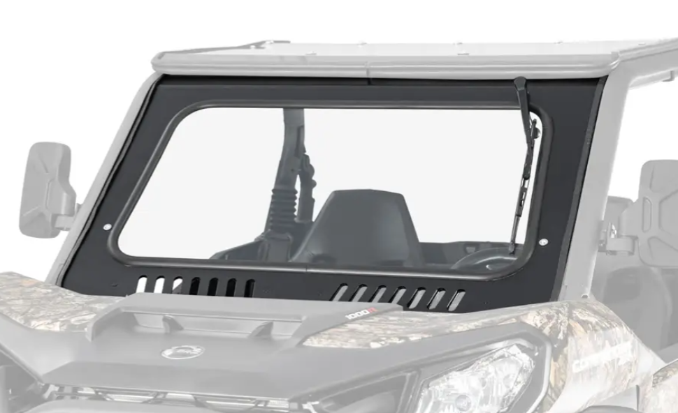A close-up of the Can-Am Commander Glass Windshield shows its sturdy, black-framed glass with a single wiper, mounted on an off-road vehicle featuring a camouflage hood and roof.