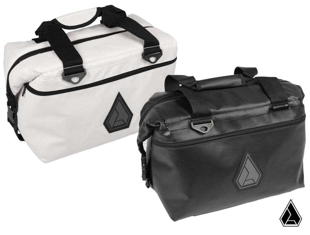 Two Assault Industries RUXAK Rugged Offroad Cooler Bags—one white, one black—each with black zippers, handles, side buckles, and a triangular geometric logo on the front. Both bags are rectangular and set against a white background.