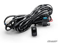 The LED Light Wiring Harness with Rocker Switch features a coiled black harness with connectors, a blue fuse, and a rocker switch labeled LED WORK LIGHTS with two LED symbols, shown on white background with the SuperATV logo.