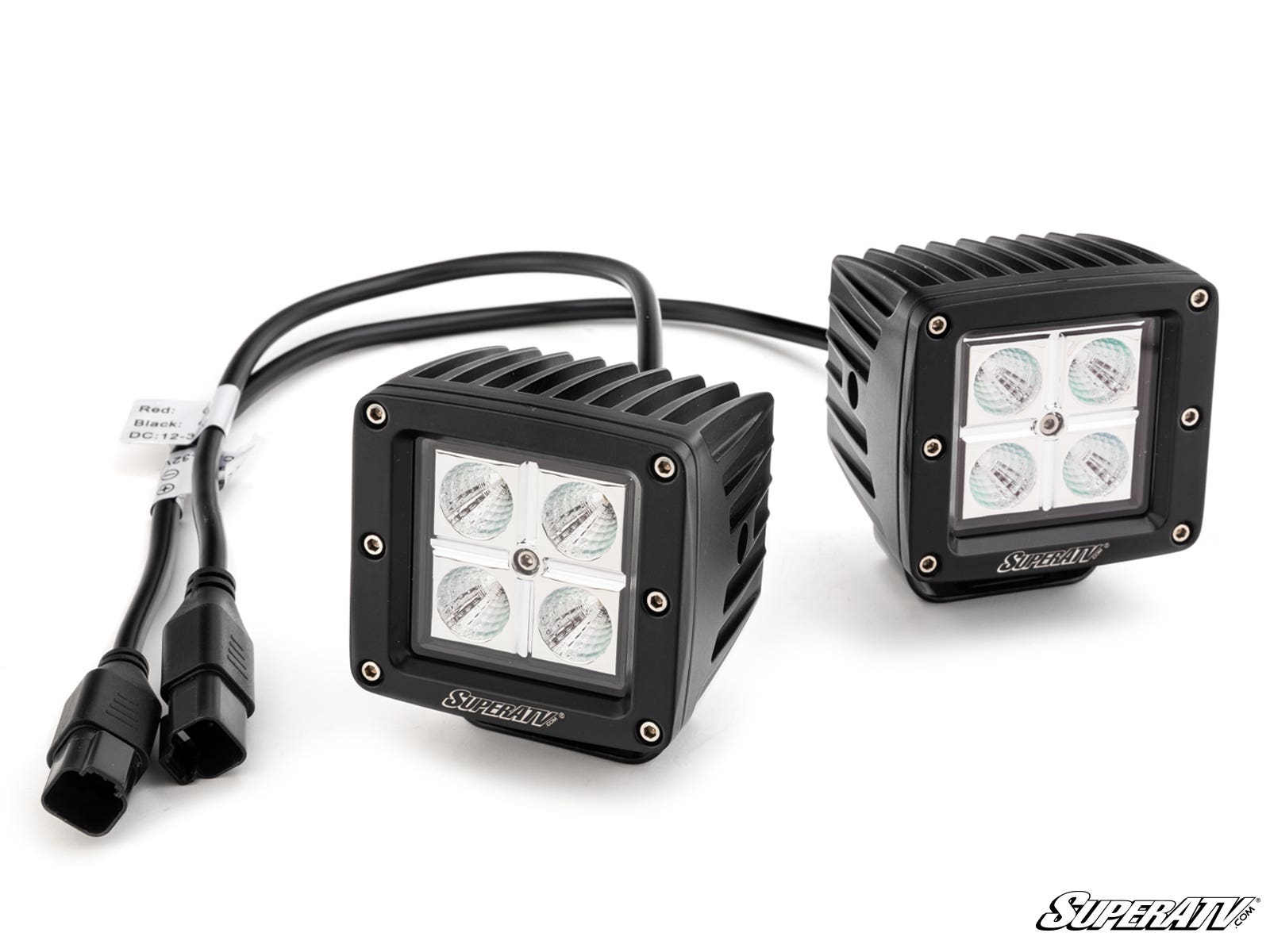 Two black, square Can-Am Defender Rear-Facing LED Cube Lights with ribbed sides, clear fronts housing four LEDs each, and power cables with black connectors. The SuperATV logo is on the lights and in the bottom right corner.