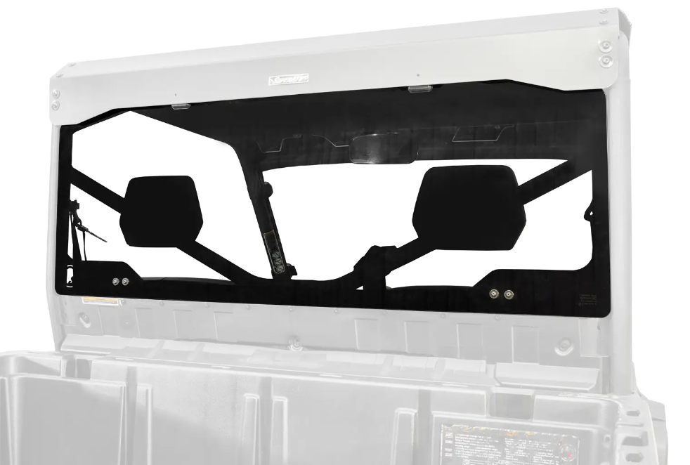 A Can-Am Defender Rear Glass Windshield is installed on a utility vehicle above the cargo bed. It features two black panels with geometric cutouts for visibility, securely attached using bolts and visible brackets.
