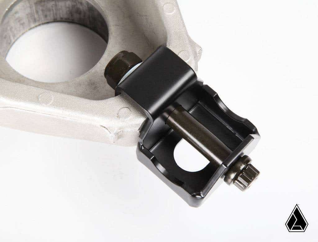Close-up of the Assault Industries Radius Rod Double Shear Bracket Kit for Can Am Maverick X3, featuring a large circular opening on one end and a black jointed connector with a bolt, displayed on a white background with logo in the corner.