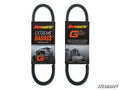Two black, oval-shaped Yamaha Kodiak Heavy-Duty CVT Drive Belts are packaged with black-and-orange labels stating SuperATV Extreme Badass Performance Belt and G Boost. One label has an off-road vehicle graphic; SuperATV logos appear in the corners.