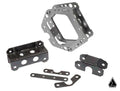 The Assault Industries F-22 Front Structural Reinforcement Kit (Fits: Maverick X3 XDS/XRS/XRC) is displayed with its metal bracket parts, featuring multiple holes and cutouts, neatly arranged on a white background with a small black logo in the corner.