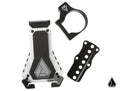 The Assault Industries Cell Phone Holder set includes a silver and black case with angled edges and logo, a black circular money clip, and a perforated black plate—displayed on white with a small triangular logo in the corner.
