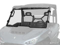 A Segway Fugleman UT10 Scratch-Resistant Full Windshield, tinted and clear, is mounted on a gray UTV with four black clamps and a central horizontal seam. The front seats, steering wheel, and roll cage are also visible inside the vehicle.