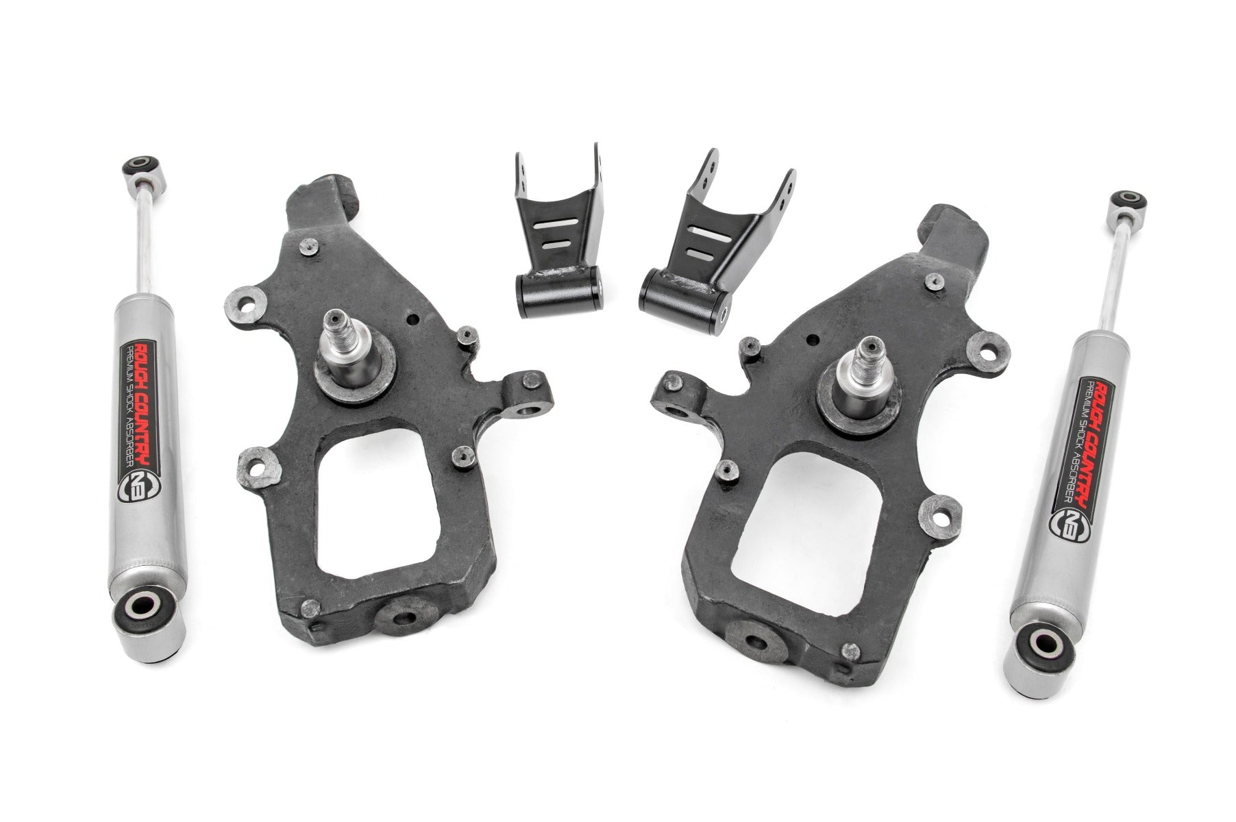 The Lowering Kit | 2 Inch FR & RR for Ford F-150 2WD (2004-2008) includes two black metal spindles, two Rough Country silver shock absorbers, and two small metal brackets, shown neatly arranged on a white background.