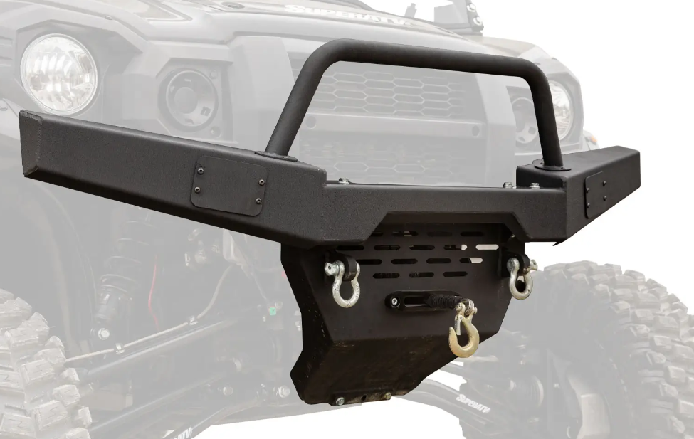 A Kawasaki Mule Pro Winch Ready Front Bumper in black is mounted on a vehicle, featuring a grille guard, built-in winch plate, skid plate, and D-ring mounts with hooks. Parts of the off-road vehicle appear faded in grey in the background.
