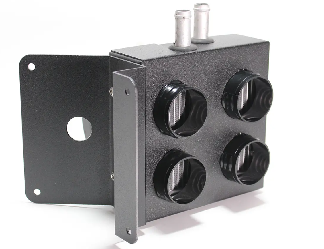The Inferno Cab Heater Kit With Defrost for 2016-Current Polaris General features a black metal panel with four circular vents, two metal pipe connectors on top, and a mounting bracket with a round hole, pictured on a white background.