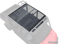 The Gravely Atlas JSV 6400 Tinted Roof, a dark polycarbonate panel secured with bolts, is installed on a red four-seat utility vehicle. It covers the passenger area for protection and visibility; the SuperATV logo appears in the bottom right corner.