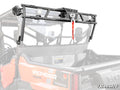 A Pioneer 1000-6 Game Loader Rack with a mounted winch and LED lights is installed on the bed of an orange Honda Pioneer 1000 UTV. The rack features a red winch strap and displays the SuperATV logo in the corner.