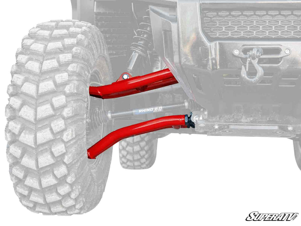 Close-up of the Honda Pioneer 1000 Atlas Pro 1.5 Forward Offset A-Arms, shown in red on an off-road vehicle. The rugged tire tread stands out, while the SuperATV logo appears in the corner and the rest of the vehicle is faded for emphasis.