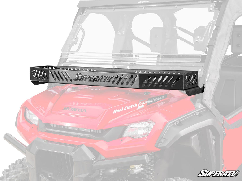 A Honda Pioneer 1000 Hood Rack Bravo, featuring a vented black metal design, is mounted above the windshield of a red Honda utility vehicle. The front grill, headlights, and “Dual Clutch Transmission” label are visible with the SuperATV logo bottom right.