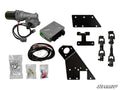 Components of the Honda Pioneer 500 Power Steering Kit—including a motor, control module, wiring harness, brackets, black shafts, metal plates, and hardware—are arranged on a white background with the SuperATV logo in the bottom right corner.