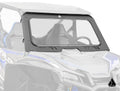 An Assault Industries Honda Talon 1000 Glass Windshield with a thick black frame and bottom cutout is installed on a blue and gray Honda side-by-side, mounted above the dashboard and steering wheel, with the logo in the lower right corner.