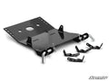 A black metal Honda Talon 1000 Plow Pro Snow Plow Mount by SuperATV, with brackets, pins, and hooks arranged on a white background. Parts include a large rectangular plate with side flanges and three smaller bracket pieces for ATV assembly.