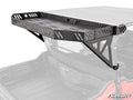 A black metal Honda Pioneer 1000-6 Bed Rack Echo with perforated sides and bottom is mounted above the cargo bed of a red off-road vehicle, secured with triangular brackets and featuring the “SuperATV” logo on the front panel.