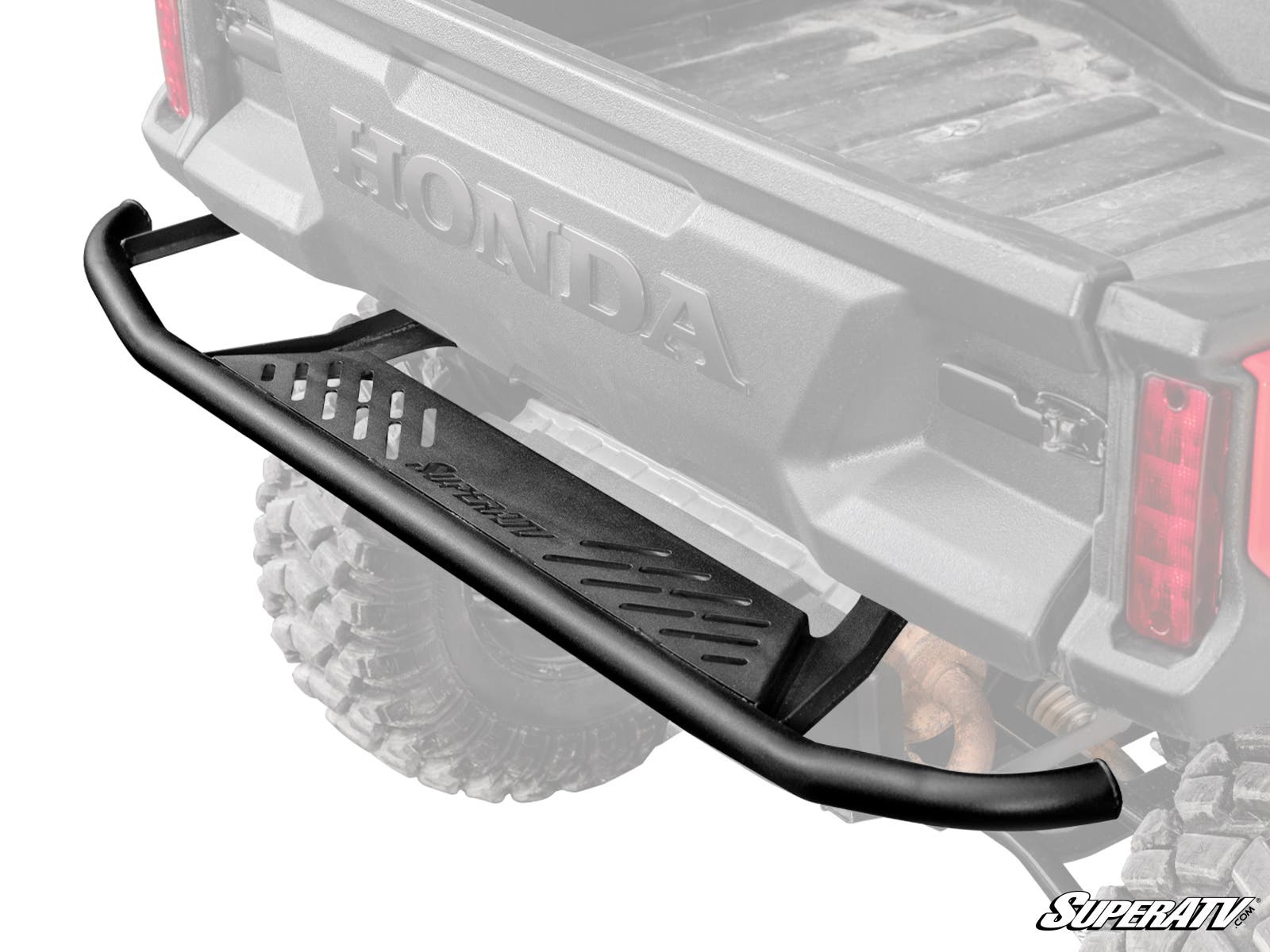 Close-up of a Honda Pioneer 1000 Rear Bumper, featuring a black, heavy-duty design with a textured metal step, diagonal cutouts, and the SuperATV logo. The bumper stands out while the vehicle bed and background are faded.
