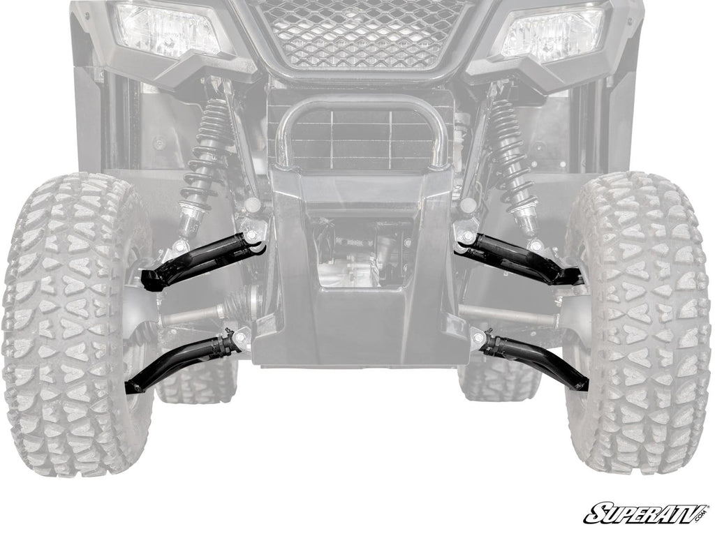 Front view of the Honda Pioneer 520 High-Clearance 1 Forward Offset A-Arms suspension system, featuring rugged black A-arms and shocks between large tires. The vehicle’s grill and headlights are visible, with the SuperATV logo in the bottom right corner.