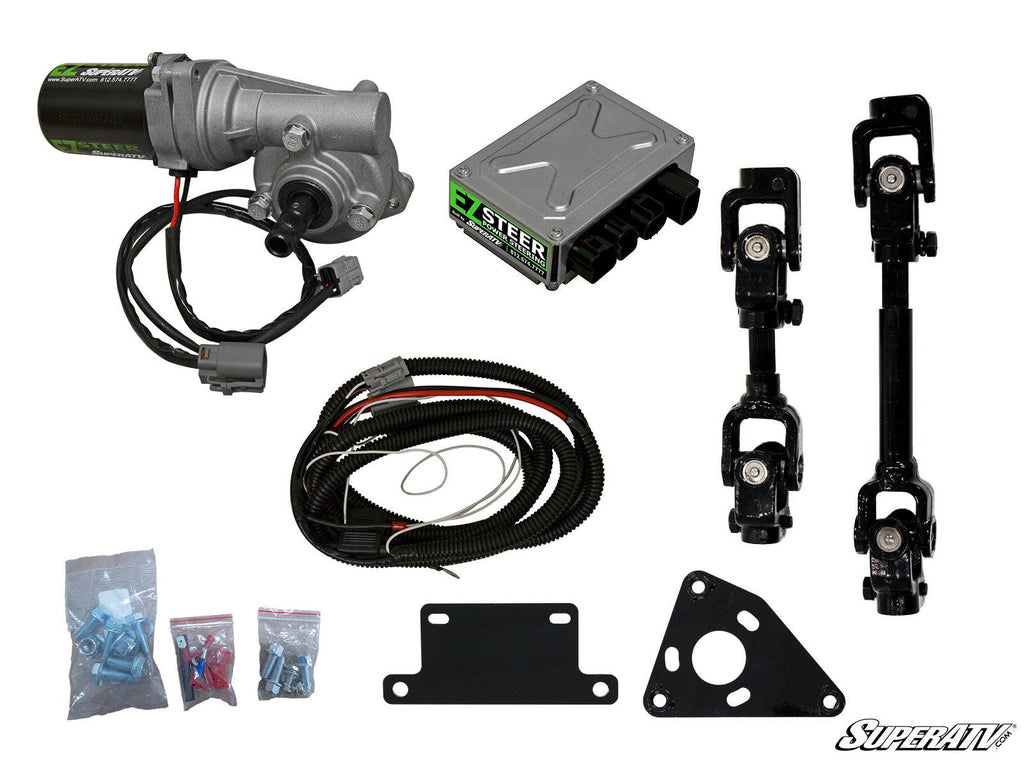 The Honda Pioneer 700 Power Steering Kit is displayed with a motor, control box, wiring harness, mounting brackets, two steering shafts, hardware packets, and a small SuperATV logo, all neatly arranged on a white background.