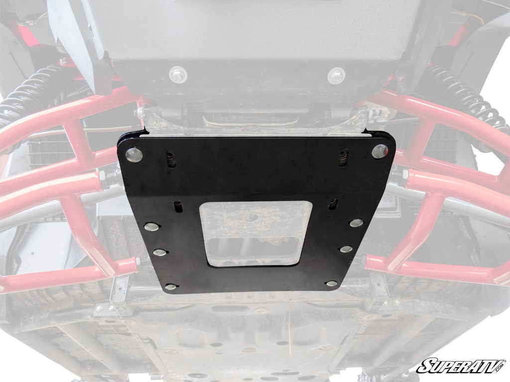 Close-up of the underside of a Honda Pioneer 1000, featuring the Frame Stiffener / Gusset Kit mounted with bolts. Red suspension parts and a SuperATV logo are visible, showcasing the vehicle’s rugged frame and added protection.