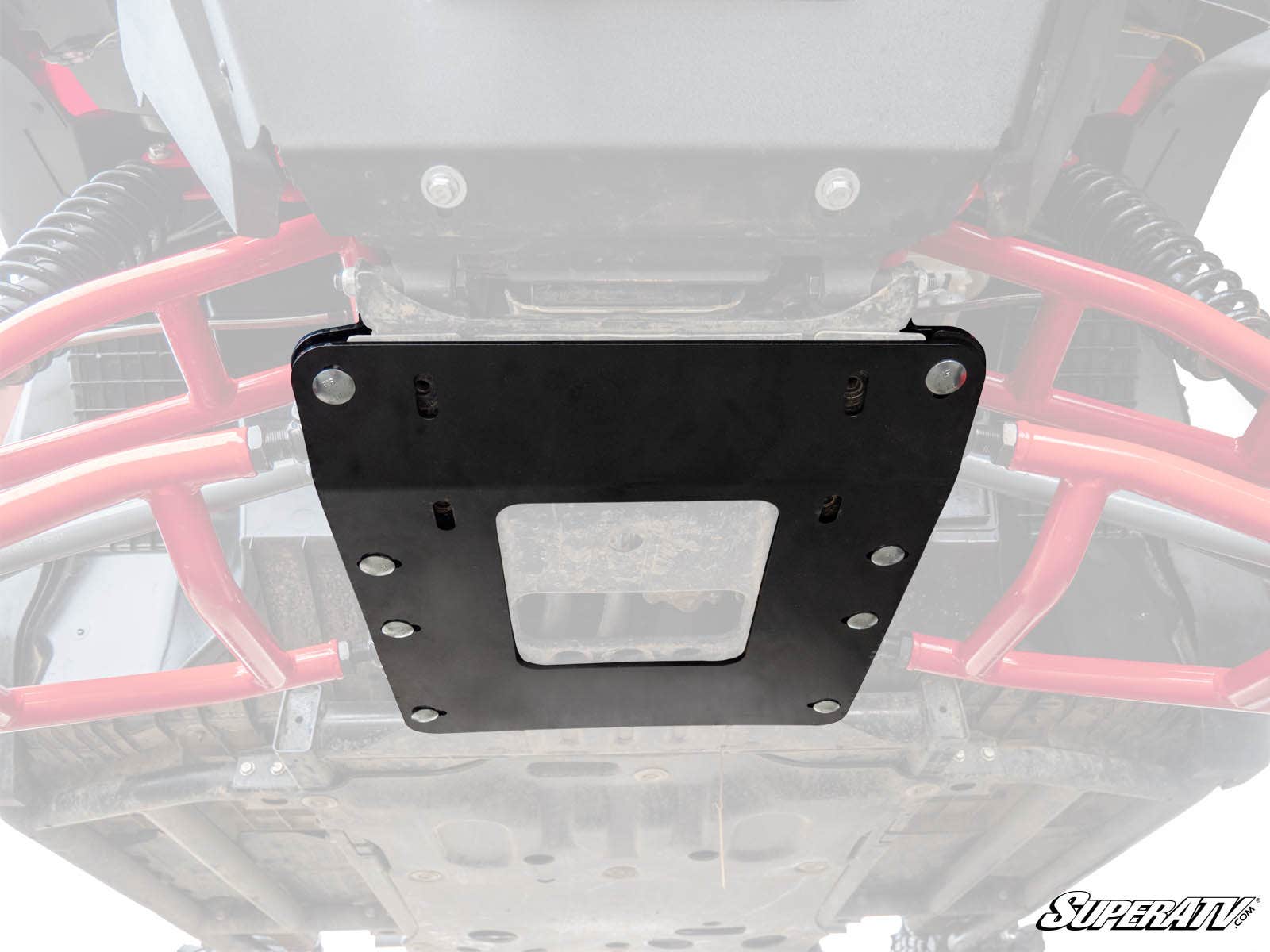 Close-up of the underside of a Honda Pioneer 1000, featuring the Frame Stiffener / Gusset Kit mounted with bolts. Red suspension parts and a SuperATV logo are visible, showcasing the vehicle’s rugged frame and added protection.