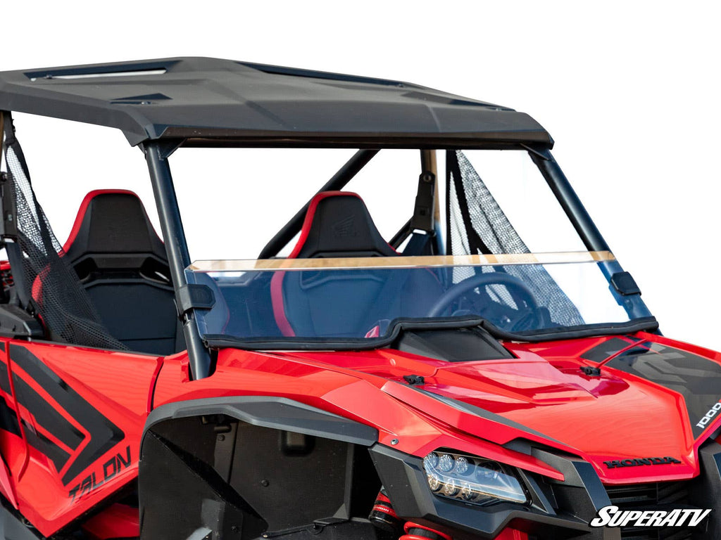 A Honda Talon 1000 off-road side-by-side, shown on a white background with the SuperATV logo, features a Honda Talon 1000 Half Windshield, black roof, mesh side nets, and sporty black-and-red seats.