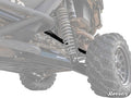 Low-angle view of a Honda Talon 1000R’s rear suspension highlights the coil spring, shock absorber, and durable Honda Talon 1000R Rear A-arms. The lifted setup with large, rugged tire is built for rough terrain. Faded, high-contrast image effect.