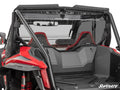 A close-up rear view of a red Honda Talon 1000 featuring the Rear Vented Windshield, two black and red bucket seats, roll bars, and the SuperATV logo. The image highlights interior and rear design details with a clear windshield.