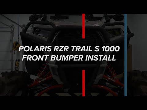 A Polaris RZR 900 with a front bumper is shown in a garage. Bold white text reads, “POLARIS RZR 900 FRONT BUMPER INSTALL,” across the image, which is divided by a vertical red and blue stripe.