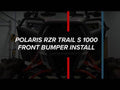 A Polaris RZR S 1000 with a front bumper is parked in a garage. Bold white text across the image reads, POLARIS RZR S 1000 FRONT BUMPER INSTALL, separated by a vertical red and blue line.