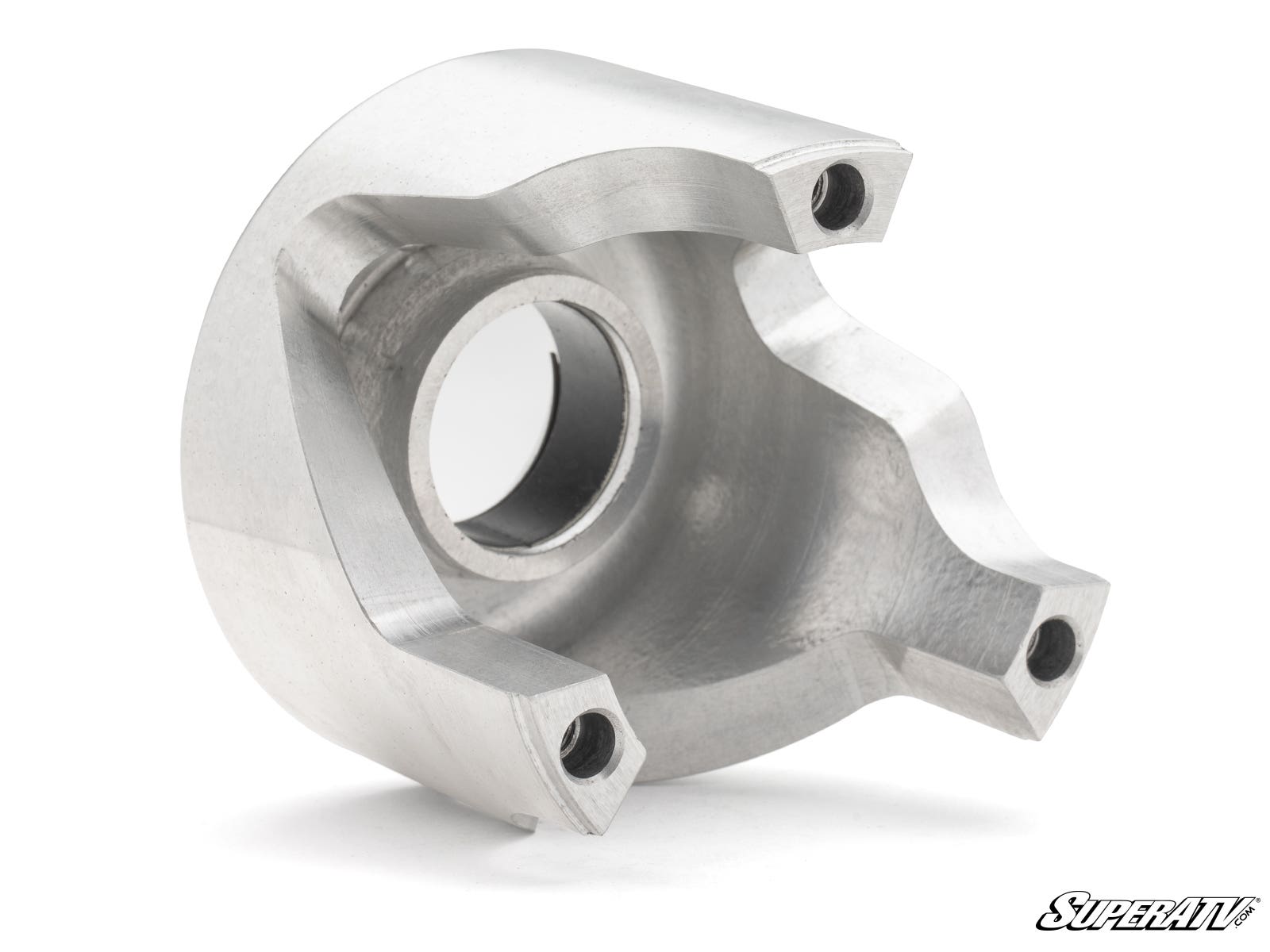 The Can-Am Defender HD10 Rev1 Clutch Kit is a machined metal part with a curved, asymmetrical design, a large central hole, three smaller threaded holes on the edges, and a smooth metallic finish. The SuperATV logo is at the bottom right.