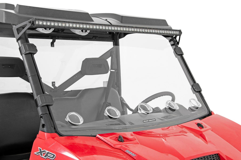 A red Polaris Ranger 1000 with a Vented Full Windshield (Scratch Resistant), five round LED lights below the glass, and a long LED bar on top. The steering wheel and headrest are visible through the windshield.