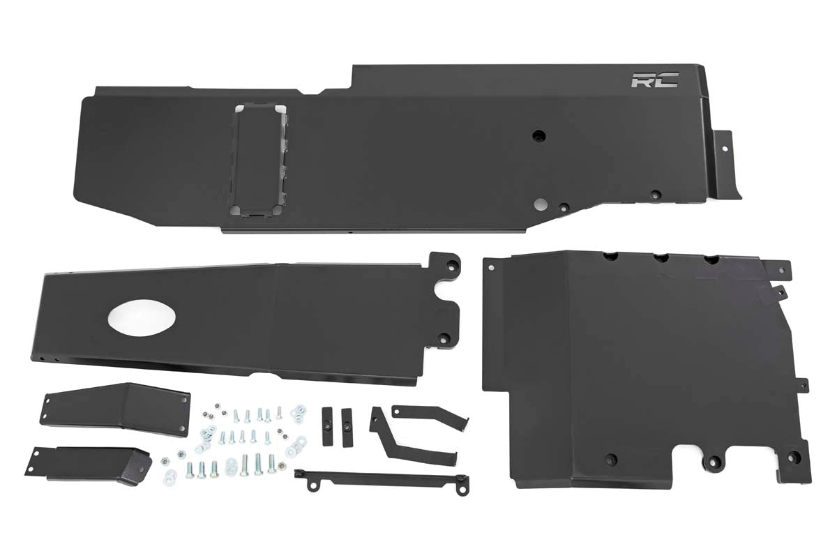 The Rough Country Skid Plate Combo for 3.6L Jeep Wrangler JL (18-19), with black metal plates and mounting hardware—screws, bolts, brackets—features a logoed largest plate and cutouts for components, all neatly unassembled on a white background.