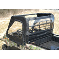 A close-up of a camouflage utility vehicle featuring the Kawasaki Mule Pro-Mx Soft Door Rear Window Combo with black soft cab enclosure and clear plastic windows, covering the top and sides for protection. The vehicle is parked on dry grass.