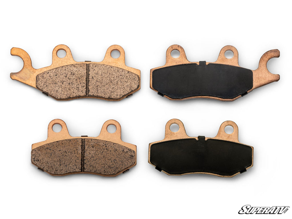 Four Kawasaki Teryx Sintered Brake Pads are shown on a white background in two pairs—each with one pad displaying a textured friction surface and one showing a smooth black backing plate; the “SuperATV” logo appears in the bottom right.
