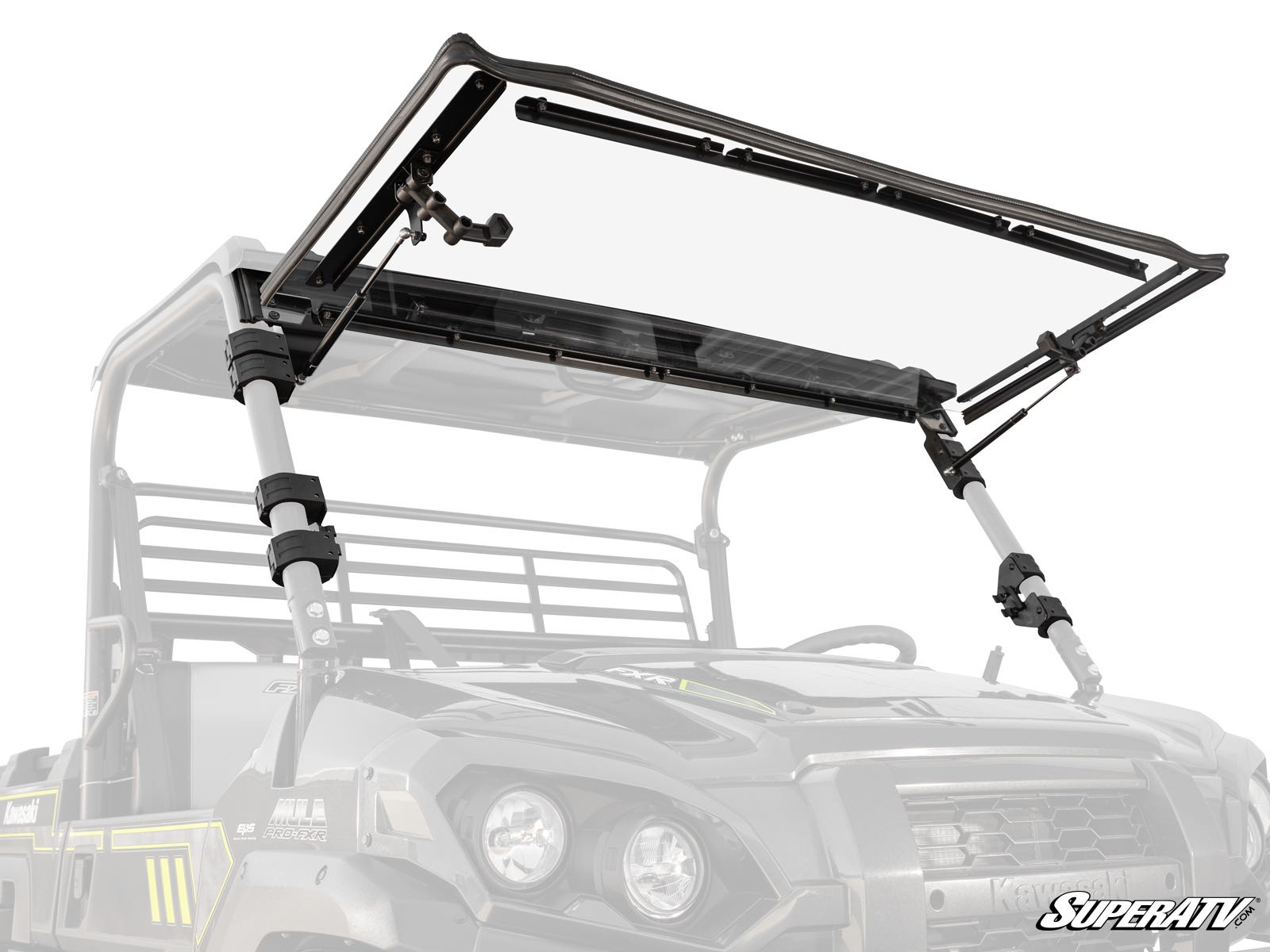 A Kawasaki Mule Pro Scratch Resistant Flip Windshield is installed on a rugged utility vehicle outdoors. The transparent windshield lifts on side support arms and mounts with brackets. The SuperATV logo appears in the lower right corner.