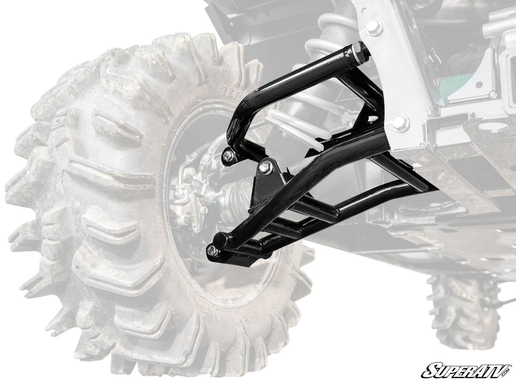 Close-up of rugged black Kawasaki Mule Pro 1000 High-Clearance 1 Rear Offset A-Arms mounted near a large off-road tire with deep treads. The faded background highlights the suspension, with the SuperATV logo in the lower right corner.