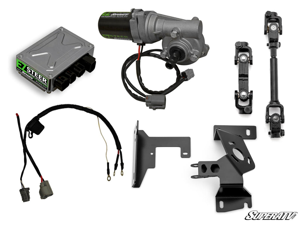 The Kawasaki Mule PRO-MX Power Steering Kit is shown on a white background with all components—electronic control box, wiring harness, motor unit, metal brackets, and linkage rods—arranged separately. The SuperATV logo appears in the lower right corner.