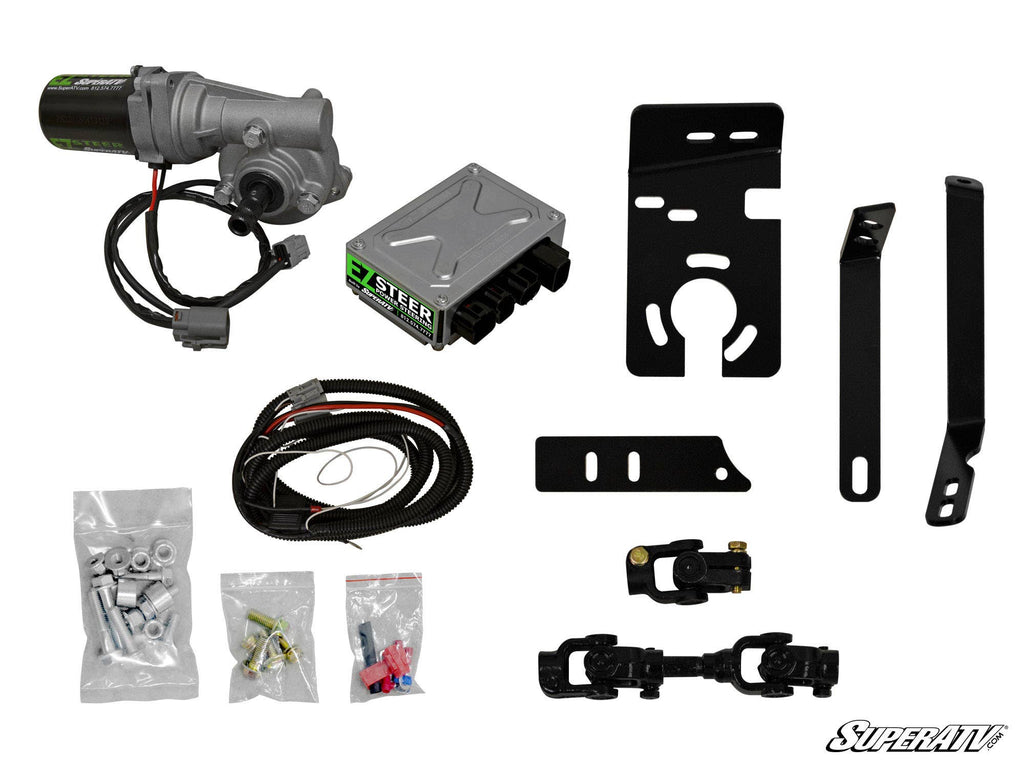 Kawasaki Mule Power Steering Kit components arranged on a white background, featuring a motor, control box, wiring harness, mounting brackets, hardware in plastic bags, and connectors. The SuperATV logo appears in the bottom right corner.