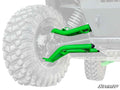 Close-up of a Kawasaki Teryx S with Atlas Pro 1.5 Forward Offset A-Arms in bright green installed on the suspension. The focus is on the green A-arms and large off-road tire, with the SuperATV logo in the corner.