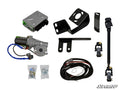 The Kawasaki Teryx Power Steering Kit is displayed with labeled parts: electronic control box, motor, brackets, universal joints, wiring harness, metal rod, and hardware bags. All components are arranged on a white background with the SuperATV logo in the