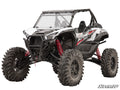 A black and white Kawasaki Teryx KRX 1000 with a 6 Lift Kit, large rugged tires, red coil shocks, a protective front grill, partially open cab, visible suspension system, and SuperATV branding in the lower right corner.